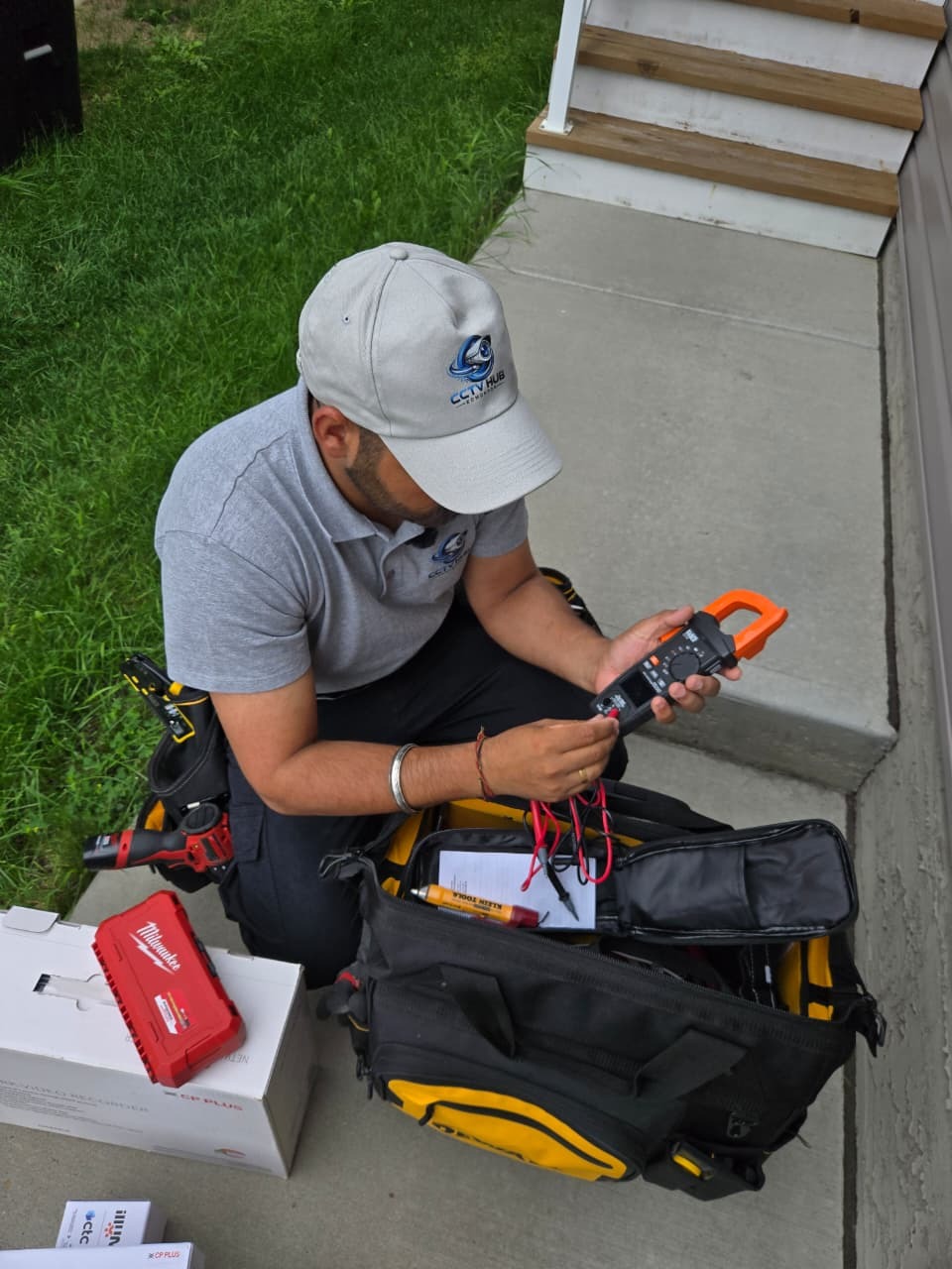 CCTV Hub Edmonton technician with DeWalt tool bag and installation equipment
